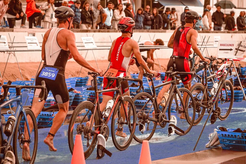 trois athlètes de triathlon avec leurs vélo au milieu des bacs